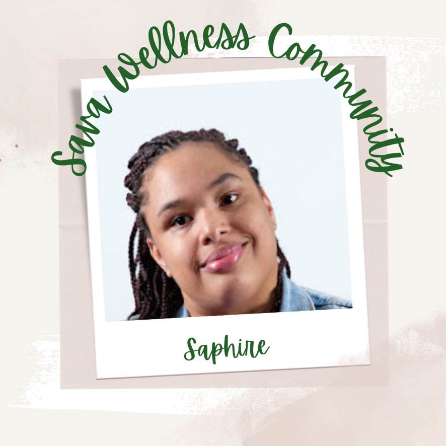 The words “Sava Wellness Community” are written in green cursive script over top of a polaroid picture. The polaroid picture is sitting on top of multiple layers of pink, cream, and white watercolour background. The polaroid picture has the name “Saphire” written in green under it. Saphire is smiling at the camera, is wearing a light blue collared shirt, and has her dark hair in braids that are pulled back.]