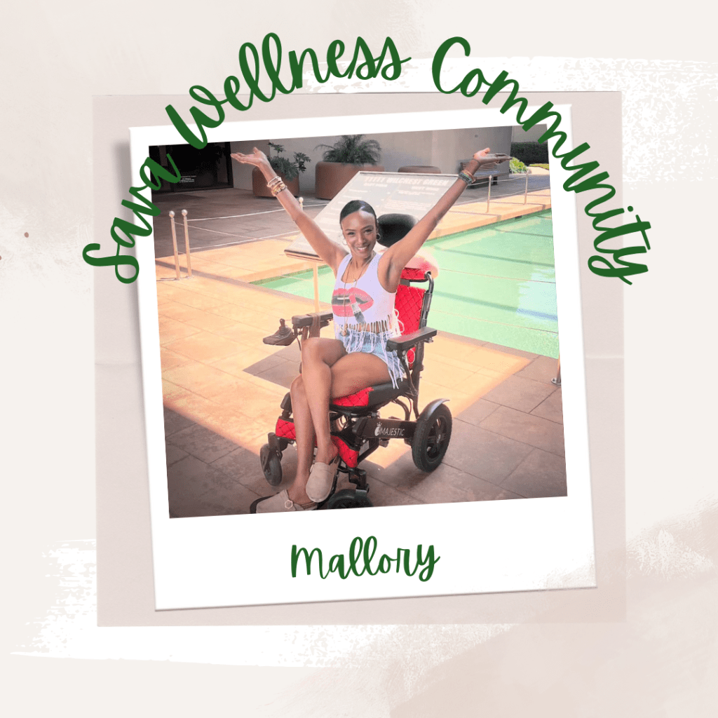 The words “Sava Wellness Community” are written in green cursive script over top of a polaroid picture. The polaroid picture is sitting on top of multiple layers of pink, cream, and white watercolour background. The polaroid picture has the name “Mallory” written in green under it. Mallory is smiling at the camera with her arms thrown up and has her hair pulled back. She has her legs crossed and is sitting in a wheelchair in front of a pool. She is wearing a tank top, hoop earrings, bracelets, a long necklace, jean shorts, and beige shoes.]