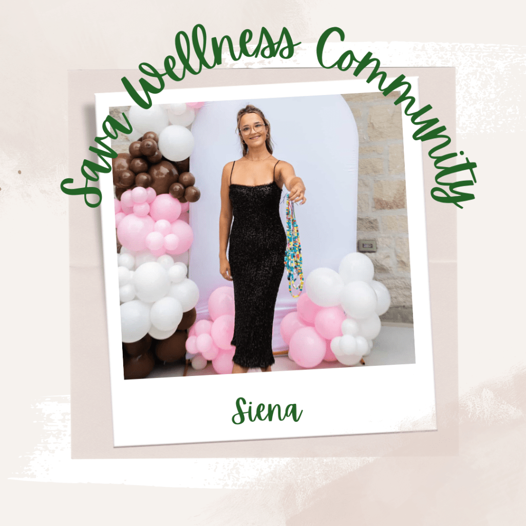 The words “Sava Wellness Community” are written in green cursive script over top of a polaroid picture. The polaroid picture is sitting on top of multiple layers of pink, cream, and white watercolour background. The polaroid picture has the name “Siena” written in green under it. Siena is wearing a sparkle black dress in front of a background of balloons. She is holding strings of multi-coloured beads.